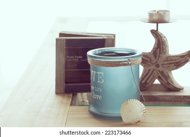 Idea Of Interior Decor In Beach Cottage Style With Trendy Glass Candlestick And Rustic Photo Frame.