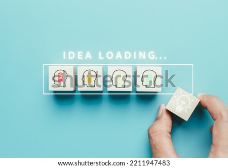 Idea loading concept. Thinking innovation and creativity process and problem solving solution business technology. Hand putting cube block with light bulb icon.