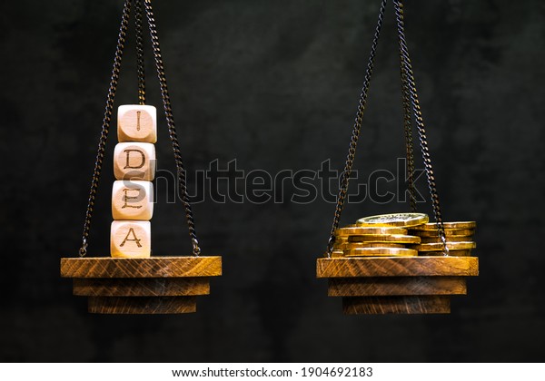 The idea is on the scale in a counterbalance with\
yellow shiny coins on another bowl on a dark background.\
Background. The concept of the value of an idea, its sale, making\
money, investing, and so on