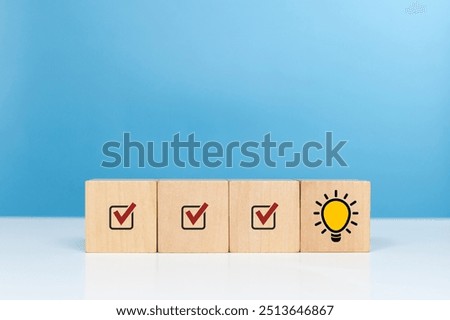 Idea, solution, step, creative and generating creative ideas. Wooden cube with check mark and bright light bulb symbol Indicates prioritization
