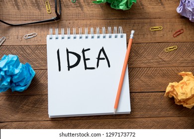 idea text writeen on notebook with papers on table