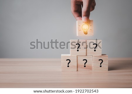 Idea wood block Concept. hand holding block Stacked together and then have Symbolic question Is to doubt the ignorance The wooden block above is a light bulb and is lit to show creativity, ingenuity.