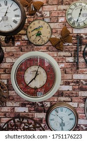 Ideal Home Show, London - June, 2019. 
 Multiple Clocks For Sale On Red Brick Wall.