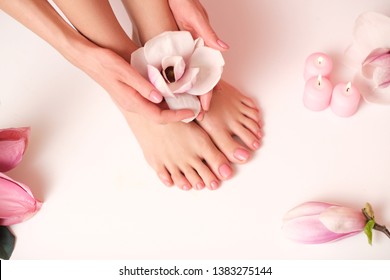 Ideal pedicure and manicure spa shoot. Female hands holding a magnolia flower.