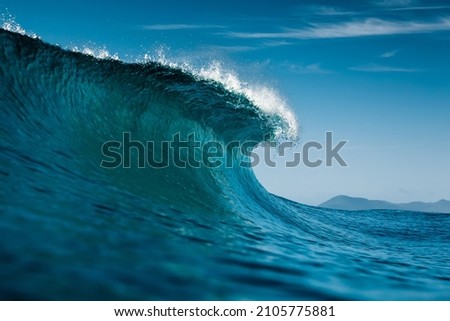 Ideal surfing wave in Atlantic ocean. Blue glassy barrels and clear sky