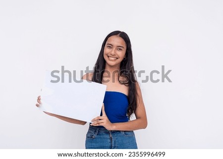 An idealistic young Filipino woman smiling while holding a blank white signage or placard. Isolated on a white background.