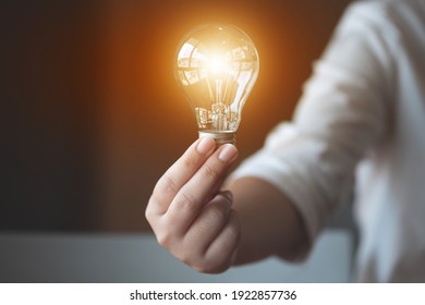 Ideen Kreativitätskonzept, Frau, die eine Glühbirne im Amt hält.