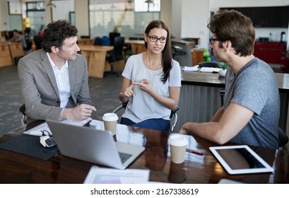 THe Ideas Are Flowing. Shot Of Three Coworkers Talking Together In An Office.