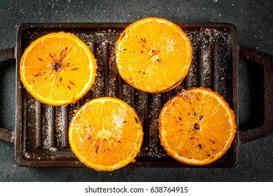 Ideas for a healthy dietary vegan breakfast. Paleo diet. Grilled oranges grapefruits. In the grill pan on a black stone table. Copy space top view  - Powered by Shutterstock