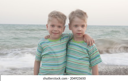 Identical Twin Children On The Beach