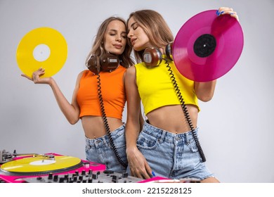 Identical Twin Female DJs Dancing Behind Record Turntables