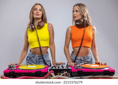 Identical Twin Female DJs Dancing Behind Record Turntables