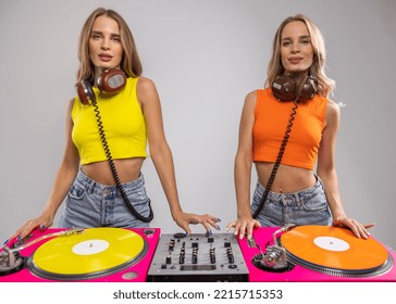 Identical Twin Female DJs Dancing Behind Record Turntables