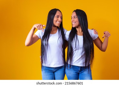 Identical Twin Sisters Pointing Down With White T-shirt And Copy Space