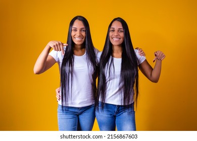 Identical Twin Sisters Pointing Down With White T-shirt And Copy Space