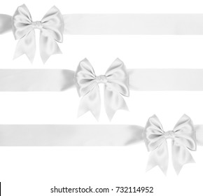 Identical white bow with tails on ribbon for Christmas gifts isolated on white 