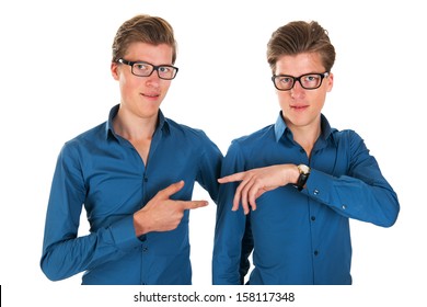Identically adult male twins pointing to each other in studio