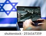 IDF army operative engaged in surveillance mission using notebook, looking at aerial map of conflict zone. Intelligence corps officer isolated over Israel flag monitoring zone of interest