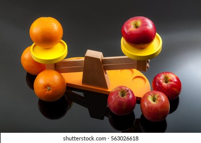 The idiom, comparing apples and oranges, refers to the differences between incomparable or incommensurable items. The concept is illustrated by 2 groups of apples and oranges on a balance scale
