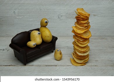 An Idiom Concept Couch Potato, Showing A New Vegetable Family On A Sofa Chair With A Fried Stack Of Crisps On A Wooden Plank Display Board.