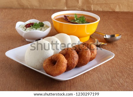 Idli or idly, is a healthy Indian, vegetarian, traditional and popular steam-cooked rice cakes, and vada, with bowls of chutney and sambar as side dishes.