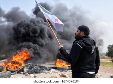 IDLIB, SYRIA, Syrians protest and burn tires in an attempt to block traffic on the M4 highway, which links the northern Syrian provinces of Aleppo and Latakia on March 15, 2020.