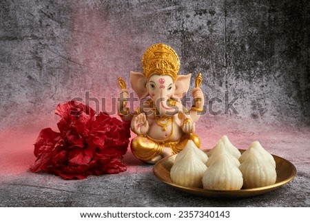 Idol of lord Ganesha with Modak Sweet Dish and flower. Ganesh chaturthi