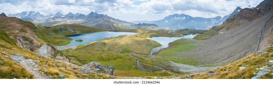 Idyllic blue alpine lake high up on the mountains, scenic landscape rocky terrain at high altitude on the Alps, panoramic view