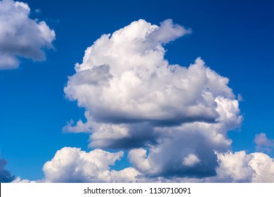 Idyllic clear blue sky with fluffy and cumulonimbus thunderstorm clouds. Bad weather harbinger concept - Shutterstock ID 1130710091