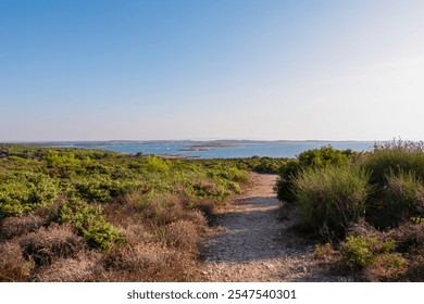 Idyllic coastal hiking trail along rocky shoreline in Cape Kamenjak National Park near Premantura, Istria, Croatia. Calm waters of Adriatic Mediterranean Sea. Hike summer seaside travel destination - Powered by Shutterstock