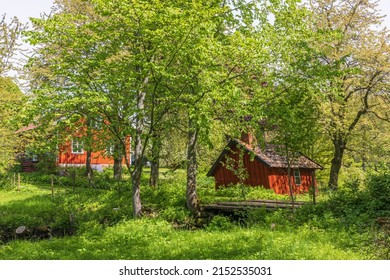 Idyllic Cottage With A Red Wooden Shed In The Garden