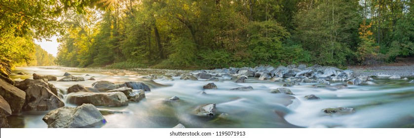 Idyllic panorama landscape in autumn on river in Forest with warm sunlight trough Trees - Powered by Shutterstock