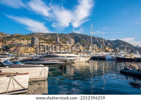 Idyllic view of the harbor (Port Hercule) of Monaco with luxury yachts and the skyline of Monaco in the background - also famous old  building 