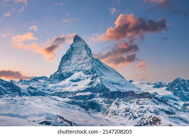 Idyllic view of snowcapped matterhorn mountain peak. Famous snow covered landscape against sky during sunset. Beautiful snowy valley in alps during winter.
