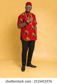 Igbo Traditionally Dressed Business Man Standing and Adjust Beads