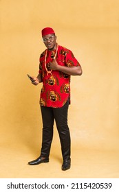 Igbo Traditionally Dressed Business Man Standing with Phone in Hand