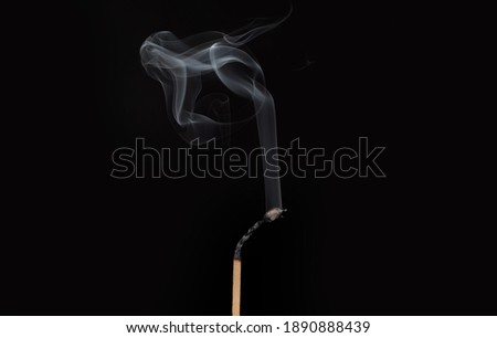 Ignition of match with smoke, isolated on black background. Match just after burning.