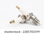 Ignition spark plug with platinum electrode. Automotive parts isolated above white background.