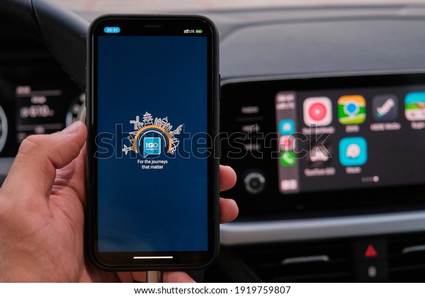 IGO logo on the\
screen of smart phone in mans hand on the background of car\
dashboard screen with application of navigation or maps. January\
2021, Prague, Czech Republic.\
