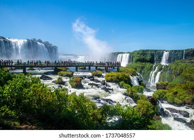 Iguazu Falls, Brazilian side. A bridge with tourists on the background of waterfalls and blue sky. - Powered by Shutterstock