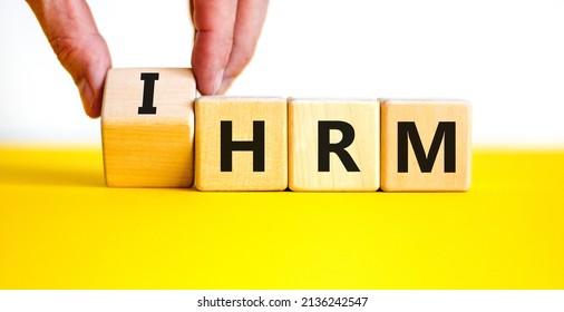 IHRM, International Human Resource Management HRM Symbol. Words IHRM, International Human Resource Management On Cubes On A White Background. Businessman Hand. Business, IHRM HRM Concept. Copy Space.