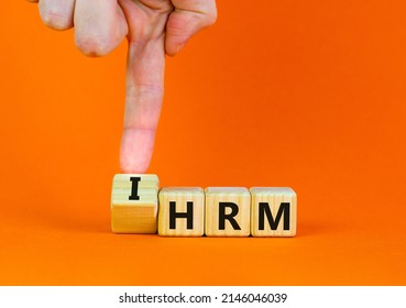 IHRM, International Human Resource Management HRM Symbol. Words IHRM, International Human Resource Management On Cubes On A Orange Background. Businessman Hand. Business, IHRM HRM Concept. Copy Space.