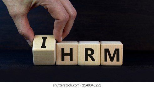 IHRM, International Human Resource Management HRM Symbol. Words IHRM, International Human Resource Management On Cubes On A Grey Background. Businessman Hand. Business, IHRM HRM Concept. Copy Space.