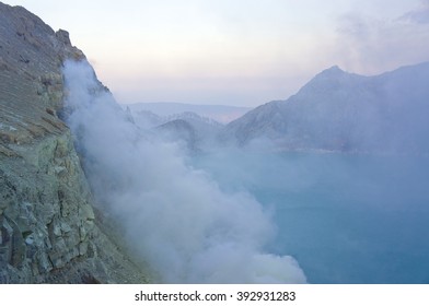 Ijen volcano in East Java contains the world's largest acidic volcanic crater lake, called Kawah Ijen, spewing out sulphur smoke in the morning. Sun is hidden in mist.
