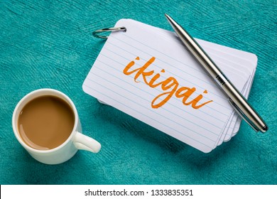 ikigai - Japanese concept  - a reason for being or a reason to wake up  - handwriting on a stack of index cards with a cup of coffee and a pen