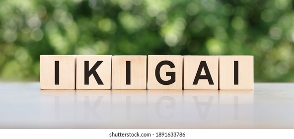 Ikigai is a Japanese concept that means a sense of your own purpose in life. The word written on a wooden block on the table.
