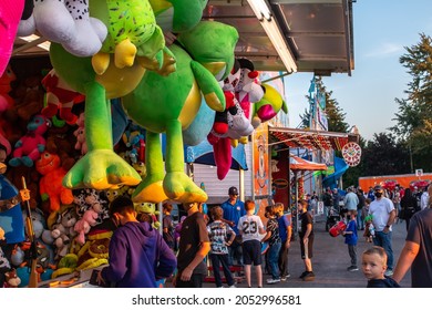 Ilderton, Ontario, Canada - October 5 2021: Children Line Up To Play Carnival Games At The Ilderton Fair Midway. It's Golden Hour On A Friday Night During The COVID-19 Pandemic.