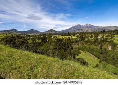 Ilinizas Volcano, Andean landscape with its crop fields and mountains showing their greenery on a clear morning, eastern view.