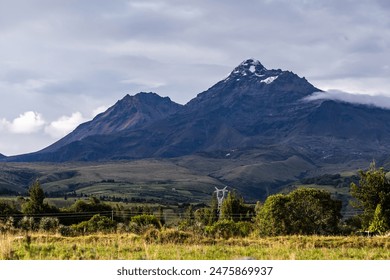 Ilinizas Volcano, Andean landscape with its crop fields and mountains showing their greenery on a clear morning, south  view.