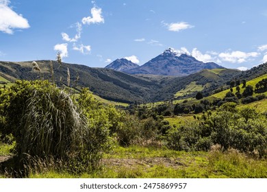 Ilinizas Volcano, Andean landscape with its crop fields and mountains showing their greenery on a clear morning, south eastern view.